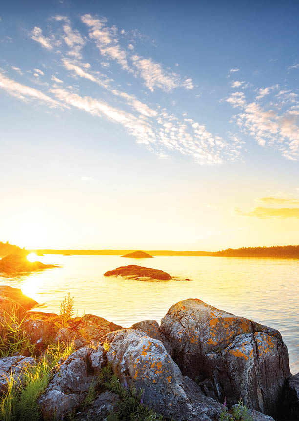 Beautiful sunset on the lake shore with a stone