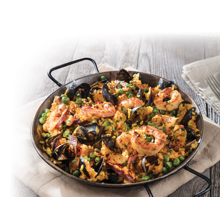 Das Bild zeigt eine k stlich angerichtete Paella – ein traditionelles spanisches Reisgericht. In der Pfanne erkennt man:  • Safranreis (goldgelb gef rbt)  • Garnelen (gro  und saftig)  • Miesmuscheln  • Erbsen  • Chorizo- hnliche Wurst oder Speckst cke  • Gew rze und Kr uter, wahrscheinlich Petersilie und Paprika  Die Paella wird in einer klassischen flachen Pfanne mit zwei Griffen serviert und steht auf einem rustikalen Holztisch, begleitet von einem Leinentuch – die Szene wirkt mediterran und sehr einladend. Ein typisches Gericht f r einen gem tlichen Abend oder ein Festessen.