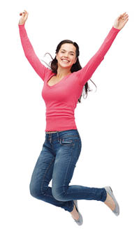 Frau mit freudigem Gesichtsausdruck springt mit nach hinten angwinkelten Beinen vor Freude in die Luft