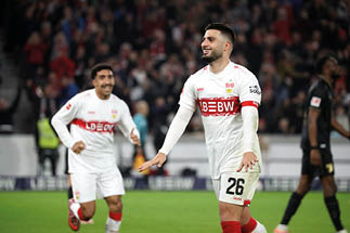 Fu ballspieler in schwarzem Trikot mit gelben Details und Kapit nsbinde l uft mit Ball auf gr nem Spielfeld.