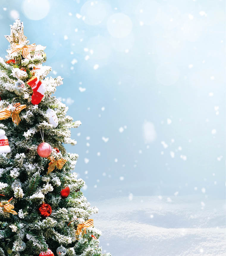 Beautiful Festive Christmas snowy background. Christmas tree decorated with red balls and knitted toys in forest in snowdrifts in snowfall outdoors, banner format, copy space.