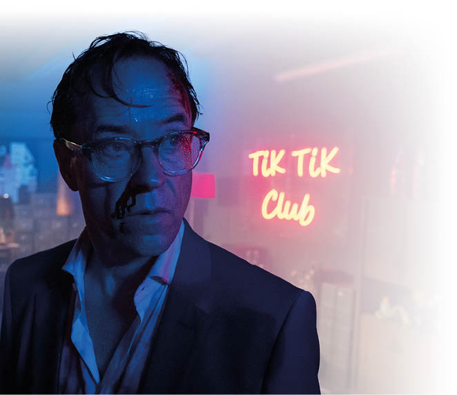 “Der schwarze Schwan": Vernau (Jan Josef Liefers) ist v llig durchn sst und seine Nase blutet. Er steht in einem dunklen Raum, im Hintergrund leuchtet eine Neonreklame mit der roten Schrift „TiK TiK Club“.