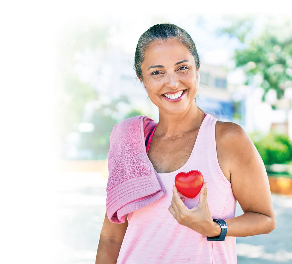 Middle age sportswoman asking for health care holding heart at the park