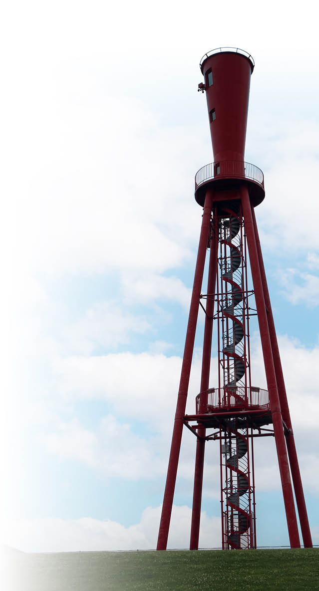 Ein hoher roter Wasserturm mit einer u eren Wendeltreppe steht auf einer gr nen Wiese vor einem bew lkten Himmel.  Beschreibung von KI generiert